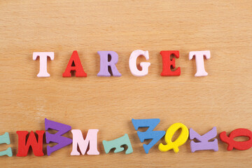 TAREGET word on wooden background composed from colorful abc alphabet block wooden letters, copy space for ad text. Learning english concept.