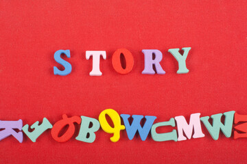 Fototapeta na wymiar STORY word on red background composed from colorful abc alphabet block wooden letters, copy space for ad text. Learning english concept.