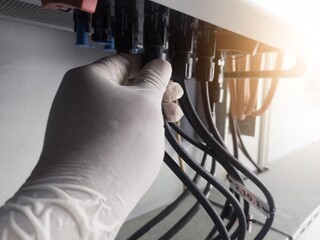 A engineering checking string cable lines in inverter solar panel.The Hand hold a string cable for...