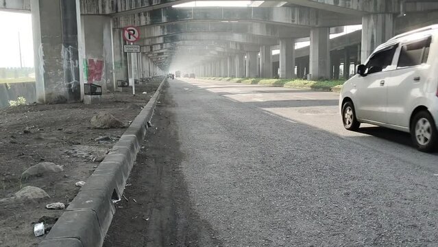 Waru, Sidoarjo, March 1, 2024. Main entrance to Pondok Chandra Indah Housing Complex. Photo time in the morning with sunlight entering between the concrete structures supporting the toll road,