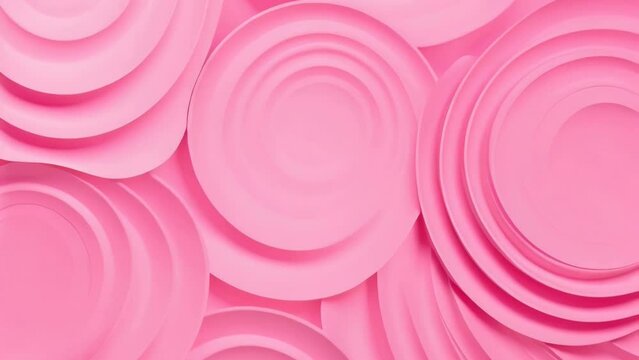 A bunch of pink plates stacked on top of each other. Suitable for kitchenware or dining concepts.