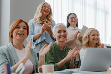 Group of mature women applauding while visiting business training class in the office - 749401828