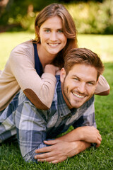 Obraz premium Couple, park and grass with smile, portrait and love for date and relationship or bonding. Man, woman and nature with romance, new york and sunshine lying together on outdoor adventure or holiday