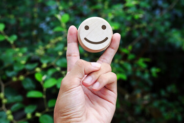 Peace hands holding wooden happy faces, International Day of Happiness concept, customer reviews,...