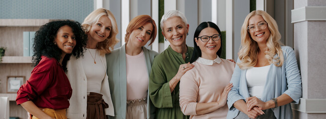 Group of mature businesswomen bonding and smiling while standing in the office together - 749407887