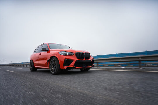 HELSINKI, FINLAND - MARCH 01, 2024: A red facelifted BMW X5 m Competition car is moving along the highway. A luxury SUV from a famous German brand.