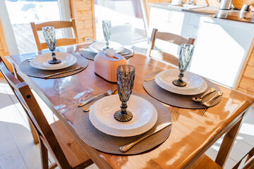 Beautiful hardwood dining table set with plates, glasses, and silverware