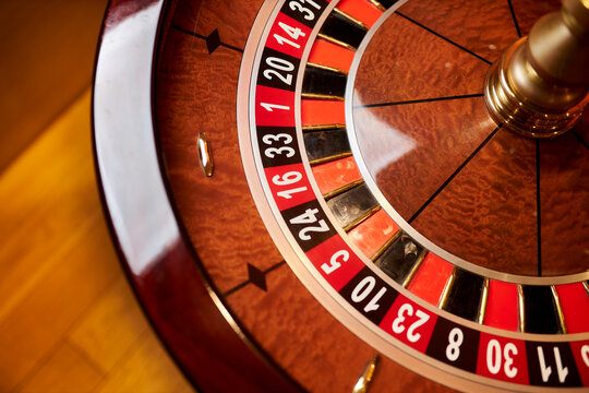 Red color casino roulette, poker game. roulette wheel. Casino theme, betting, online casino, bets, winnings. wooden casino roulette wheel with ball. Luxury casino roulette. close-up image