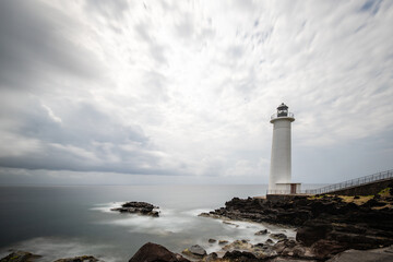 Fototapeta na wymiar Le Phare du Vieux-Fort, white lighthouse on a cliff. Dramatic clouds overlooking the sea. Pure Caribbean on Guadeloupe, French Antilles, France
