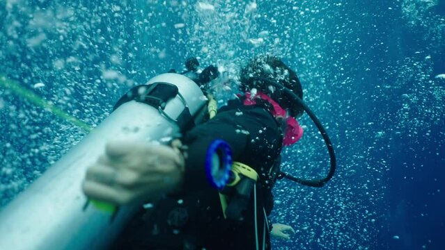A scuba diver moves through bubbles
