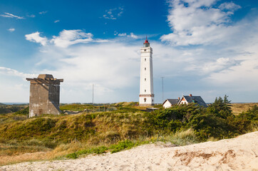 Fototapeta na wymiar Lighthouse and bunker in the sand dunes on the beach of Blavand, Jutland Denmark Europe