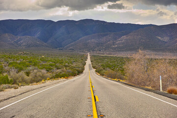 Mountain, road trip and natural landscape for travel, holiday and scenery at Anza-Borrego Desert State Park in California. Nature, cloudy sky and highway for journey, vacation and outdoor adventure.