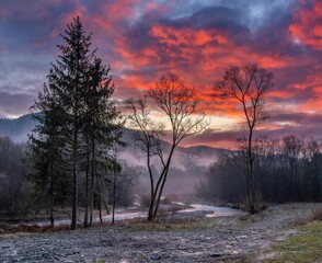 Zjawiskowy, czerwony wschód słońca nad górskim potokiem w Gorcach