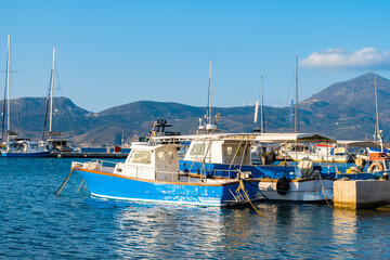 Traditional Greek fishing boats on blue sea in Adamas port bay, Milos island, Cyclades, Greece - 749449001