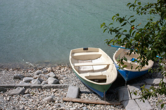 Two boats on the rocky shore of the lake. Boats on the lake near the shore, top view.