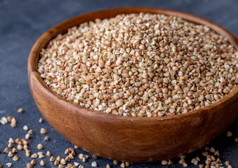 Organic Raw Buckwheat Groats in a Wooden Bowl. Healthy Eating Concept. View from Above.