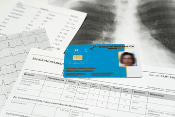 Eine blaue Gesundheitskarte liegt auf medizinischen Unterlagen, horizontal
