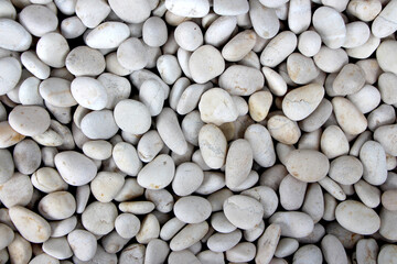 A pile of smooth, oval, matte, white, textured pebbles, perfect for a background