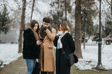 Dedicated team of young professionals working together outdoors on a snowy winter day.