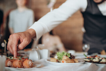 The waiter offers cold snacks, canapés. Catering, service, aperitif. Celebration, event under the open sky outside