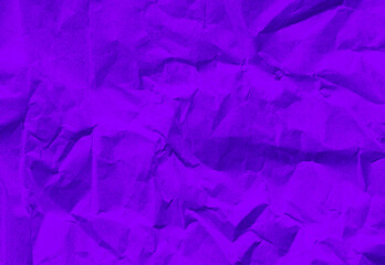 close up texture of neon purple crumpled or torn old craft paper use as background with blank space for design. creased recycle violet craft paper texture for futuristic concept.