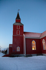 Warm light emanating from an old wooden church on a hill above Tromso, Norway