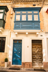 Facade of a typical house with balconies closed by typical Malta windows and doors - 749475895