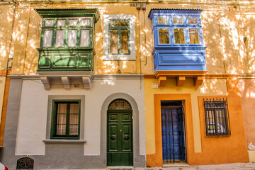 Facade of a typical house with balconies closed by typical Malta windows and doors - 749476013