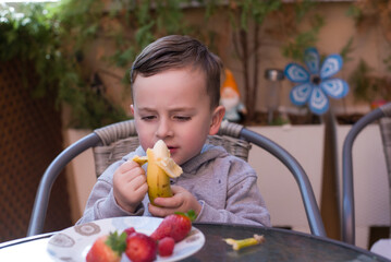Boy eating banana at home