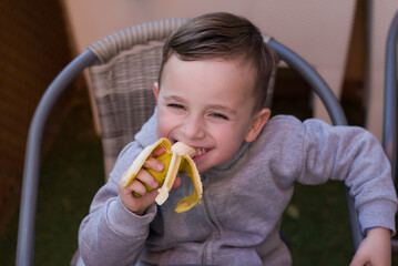 Boy eating banana at home