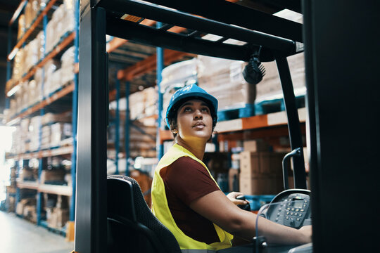 Young woman operating a forklift in the warehouse