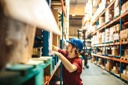 Warehouse worker organizing boxes on shelves