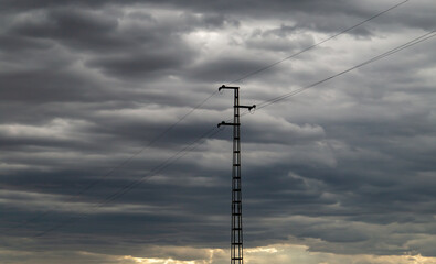 Pilón de la red eléctrica rural con un cielo nublado de tormenta. Distribución de electricidad en el mundo rural. El Granado, Huelva, Spain. - obrazy, fototapety, plakaty