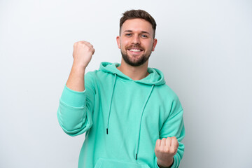Young caucasian man isolated on white background celebrating a victory