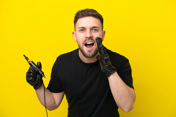 Tattoo artist man isolated on yellow background shouting with mouth wide open