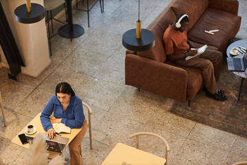 High angle view at people working in coffee shop or coworking area in office copy space