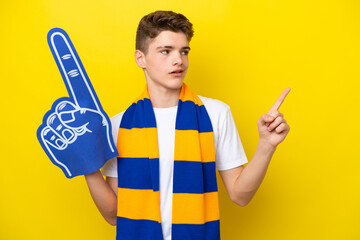 Teenager sports fan man isolated on yellow background pointing up a great idea