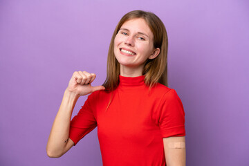 Young English woman wearing band-aids isolated on purple background proud and self-satisfied