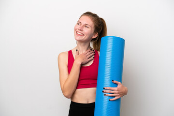 Young sport English woman going to yoga classes while holding a mat isolated on white background...