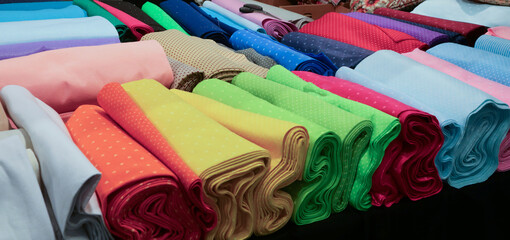 many colorful cotton and felt fabrics for sale on the counter in the tailoring and drapery shop