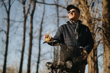 Active senior man with sunglasses enjoying a bike ride in autumn park.