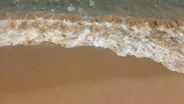 Texture of the real sea waves on a sandy beach