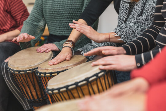 Group of people playing drums during a music therapy lessons, jembe drum, drumming concept