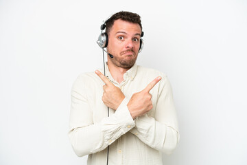 Telemarketer caucasian man working with a headset isolated on white background pointing to the laterals having doubts