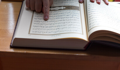 Naklejka premium Young muslim woman reading Quran in the mosque. woman praying and reading quran in mosque during ramadan