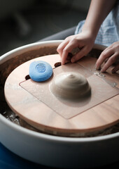 Unrecognizable Ceramics Maker working with Pottery Wheel in Cozy Workshop Makes a Future Vase or Mug, Creative People Handcraft Pottery Class
