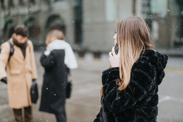 Focused young adults in professional attire walking outside as snowflakes fall. Concept of urban...