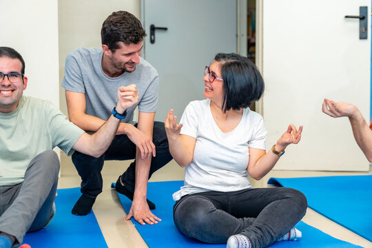 Yoga instructor talking with a disabled woman during class