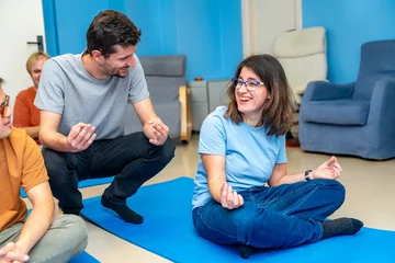 Foto op Canvas Yoga instructor teaching the lotus position to a disabled woman © unai