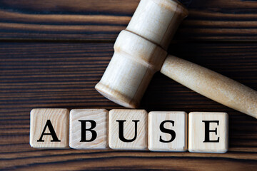ABUSE - word on wooden cubes on background of judge's gavel